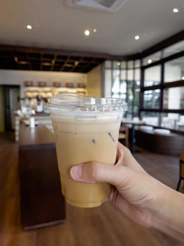 Hand on iced milk coffee, stock photo