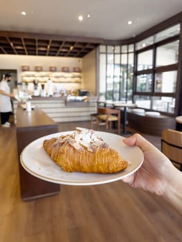 Fresh baked almond croissant and coffee breakfast, stock photo