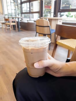 Hand on iced milk coffee, stock photo