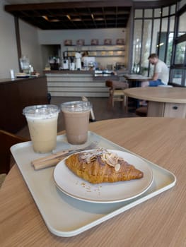 Fresh baked almond croissant and coffee breakfast, stock photo
