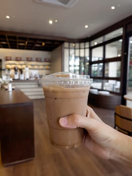 Hand on iced milk coffee, stock photo
