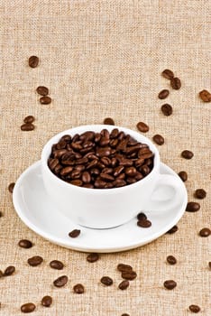 Cup of coffe beans on burlap bag