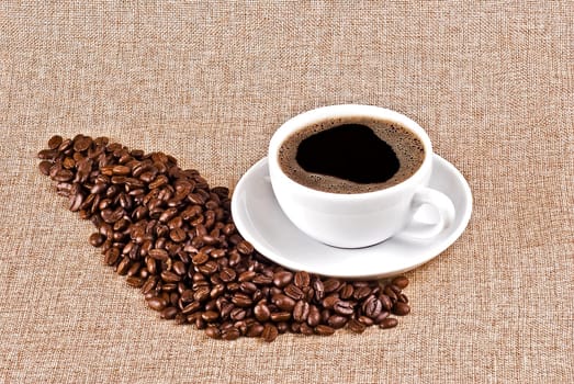 Cup of coffe and coffe beans on burlap background