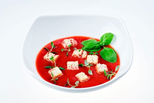 Bowl of tomato soup over white background