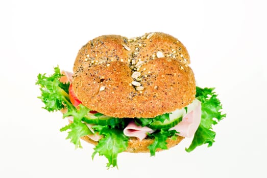 Fresh sandwich with ham and vegetables over white background