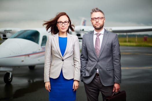 Two businesspeople looking at camera on windy day