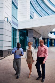 Business people interacting while walking by office building