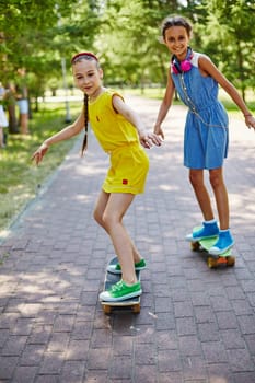Little girls skateboarding in park on summer vacations