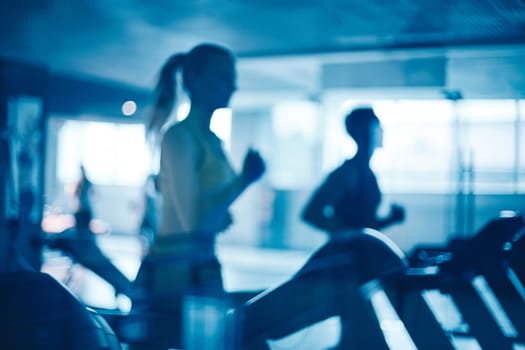 Figures of humans running on treadmills in gym