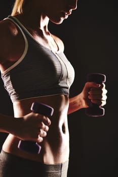Fit woman exercising with dumbbells
