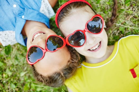 Happy girls in sunglasses relaxing outdoors