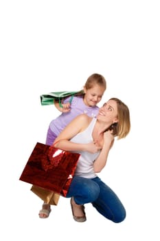 Happy  mother and daughter with shopping bags standing at studio, isolated on white background.  daughter hugging her mother