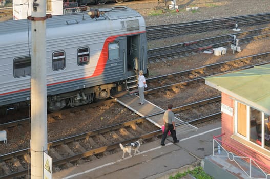 Conductor standing near the car before the departure of a passenger train from the station.
