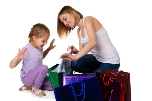 Happy  mother and daughter with shopping bags sitting at studio, isolated on white background. they admired considering buying