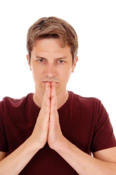 A serious young man in a burgundy t-shirt with his hands folded in front.of him, isolated for white background..