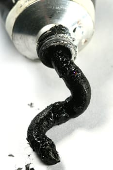 black paint in tube on white paper