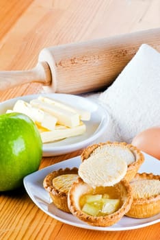 Freshly made apple pies on the table with one open
