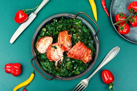 Baked chicken roll with fried spinach leaves. Space for text
