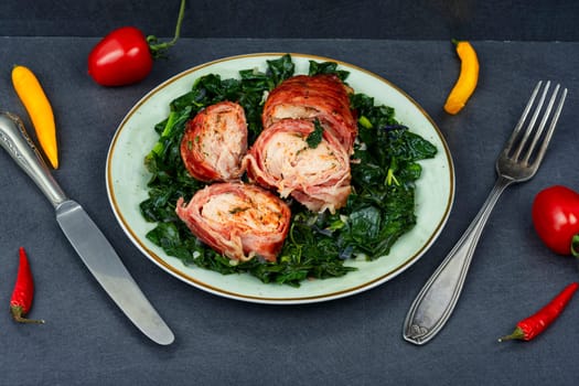 Baked chicken roll with fried spinach leaves. Space for text
