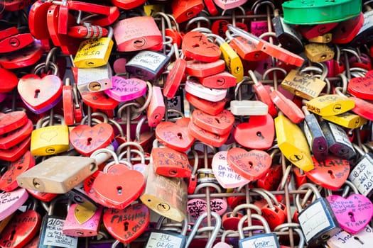 Verona, Italy - June 2022: background of heart-shaped locks on a wall, symbol of love forever