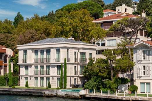 View from Bosphorus strait of the green mountains of the Asian side, with traditional houses and dense trees in a summer day, Istanbul, Turkey