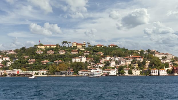 View from Bosphorus strait of the green mountains of the Asian side, with traditional houses and dense trees in a summer day, Istanbul, Turkey