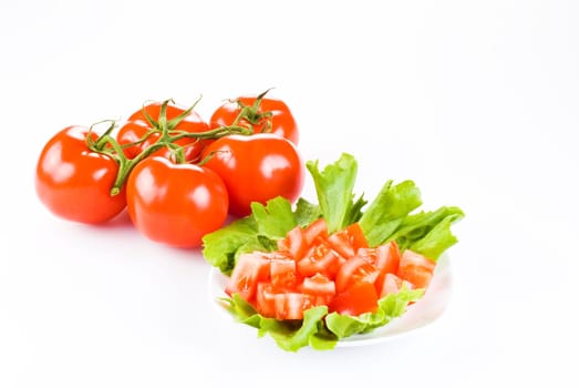 Bunch of tomatoes with one diced on lettuce