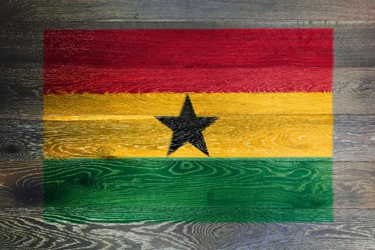 A Ghana flag on rustic old wood surface background