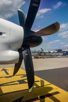 Warsaw, Poland - Jun 30, 2021. View from the window of an aircraft onto a wing to which a propeller engine is attached. The plane is landing at Warsaw Chopin International Airport.