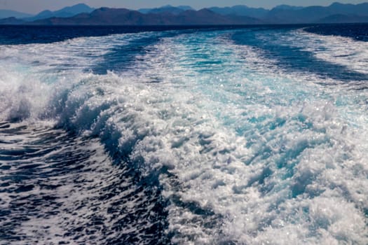 Trail on water surface or powerful stern wave behind of fast moving speedboat or ferry while cruising on ocean. Greek Aegean.