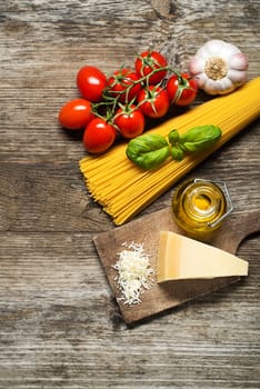 Spaghetti and tomatoes with parmesan cheese on a vintage wooden table