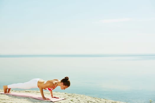 Fit woman doing pushups by the seaside