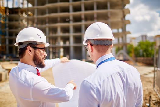 Young businessmen discussing sketch of new building