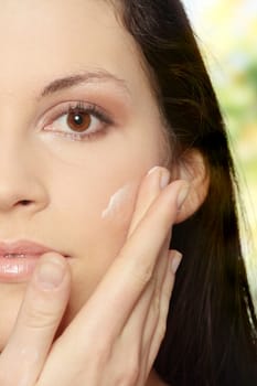 Beautiful young woman with cream.