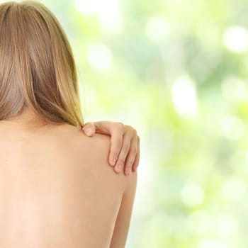 Woman from behind, naked body, pain concept,against abstract green background