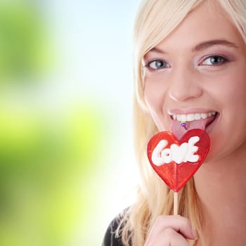 Teenage girl holding red heart shaped lollipop....