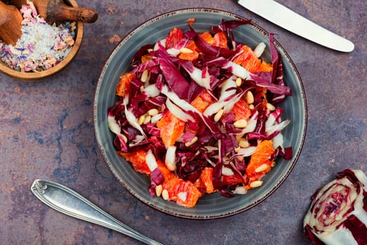 Raw chicory salad with grapefruit and pine nuts on a plate