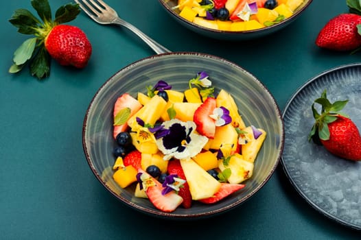 Delicious summer salad with field pansies and fruit
