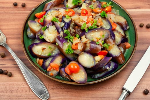 Warm purple eggplant, tomato and garlic salad. Copy space for text