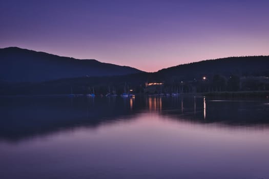 The water of the Tegernsee reflects the purple evening twilight near Gmund am Tegernsee, Bavaria, Germany