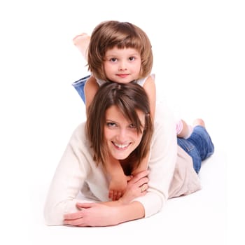 A portrait of a mother and her baby girl lying on the floor and smiling over white background