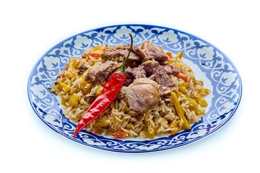 Delicious Uzbek festive pilaf in a plate on a white isolated background. High quality photo