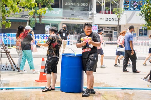 Siam Square, Bangkok, Thailand - APR 13, 2023 short action of people joins celebrations of the Thai New Year or Songkran in Siam Square Bangkok, Thailand.