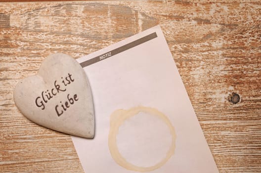 Heart with notepad on a rustic wooden table