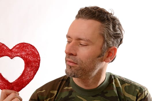 Soldier holding a red heart shape on a white background