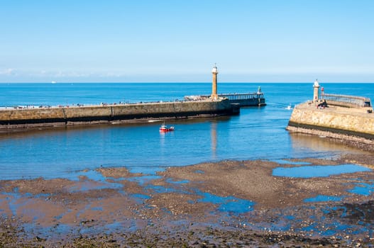 Scenic view of Whitby Pier in sunny autumn day.Whitby's attraction as a tourist destination is enhanced by its association with the world famous horror novel Dracula, written by Bram Stoker