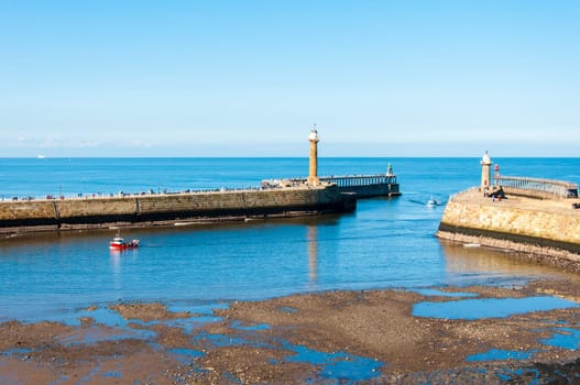 Scenic view of Whitby Pier in sunny autumn day.Whitby's attraction as a tourist destination is enhanced by its association with the world famous horror novel Dracula, written by Bram Stoker