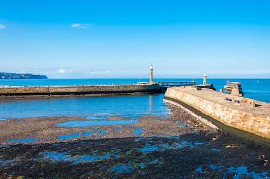 Scenic view of Whitby Pier in sunny autumn day.Whitby's attraction as a tourist destination is enhanced by its association with the world famous horror novel Dracula, written by Bram Stoker