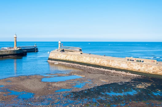Scenic view of Whitby Pier in sunny autumn day.Whitby's attraction as a tourist destination is enhanced by its association with the world famous horror novel Dracula, written by Bram Stoker