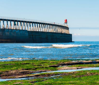 Scenic view of Whitby Pier in sunny autumn day.Whitby's attraction as a tourist destination is enhanced by its association with the world famous horror novel Dracula, written by Bram Stoker